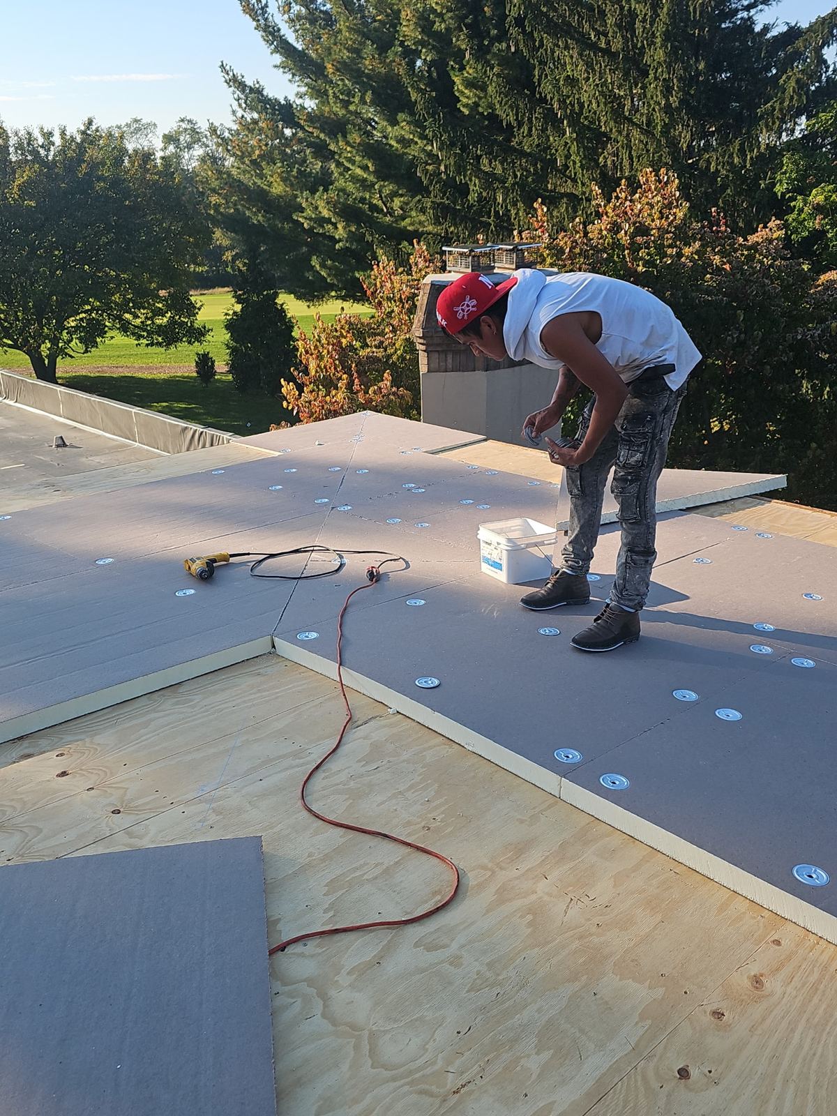 Storm Guard roofer fastening insulation board over new plywood decking