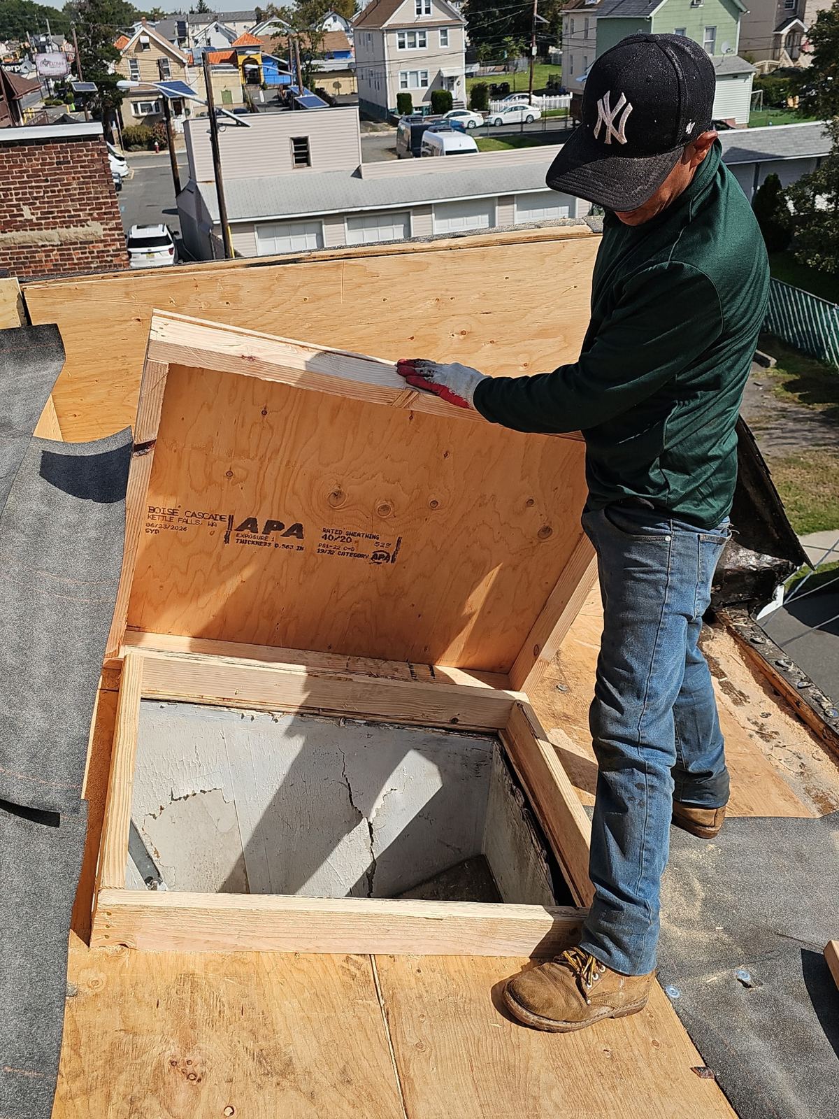 Roofer building a new wood curb for a roof access hatch